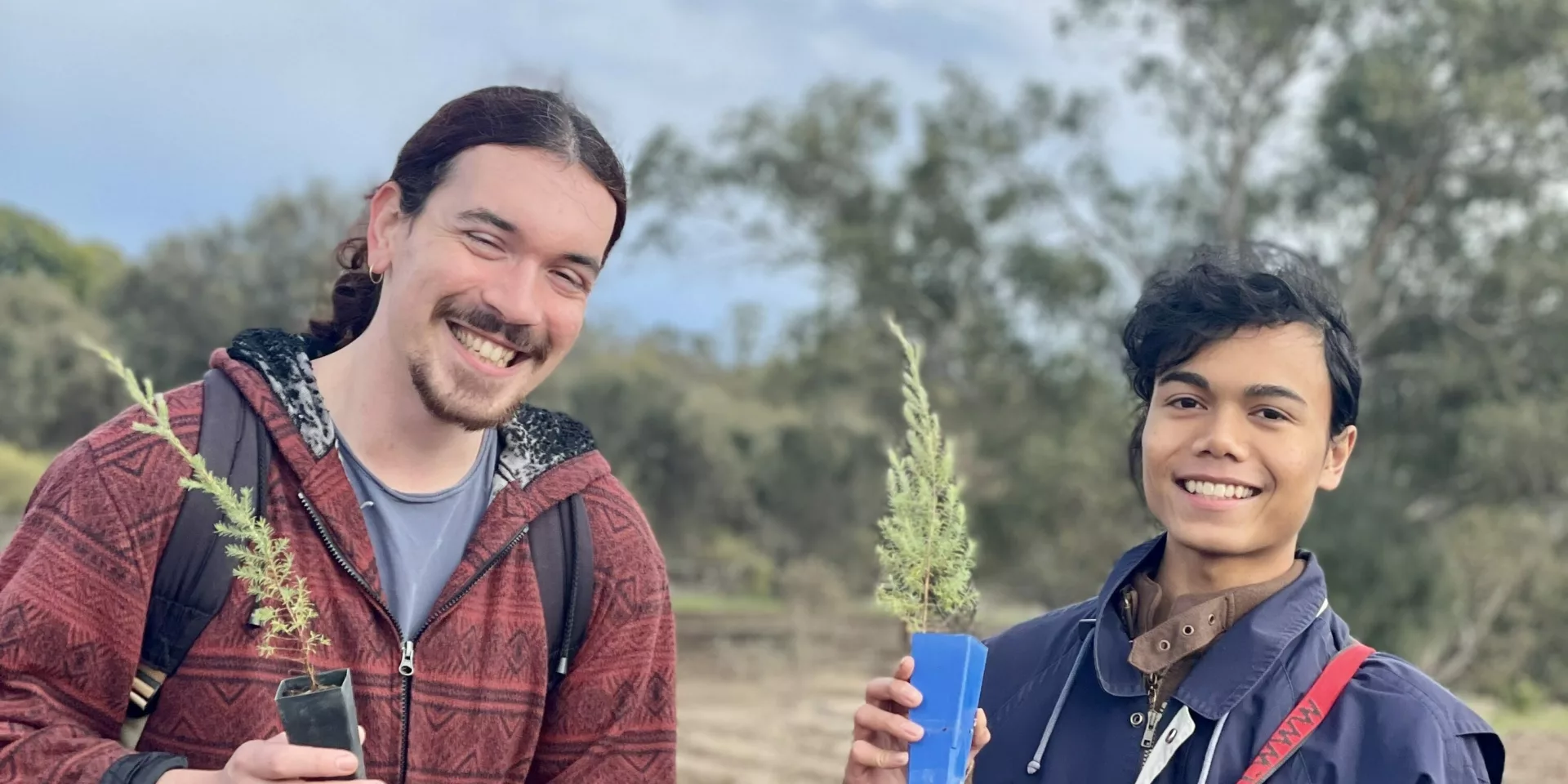 Two young men planting trees